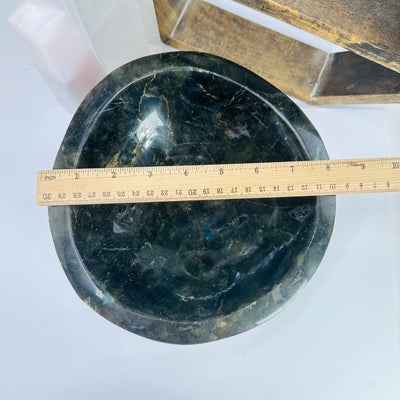 labradorite bowl next to a ruler for size reference