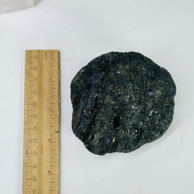 tourmaline cluster next to a ruler for size reference