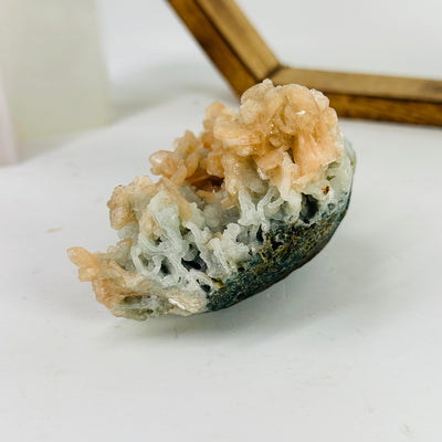 apophyllite with peach stilbite with decorations in the background