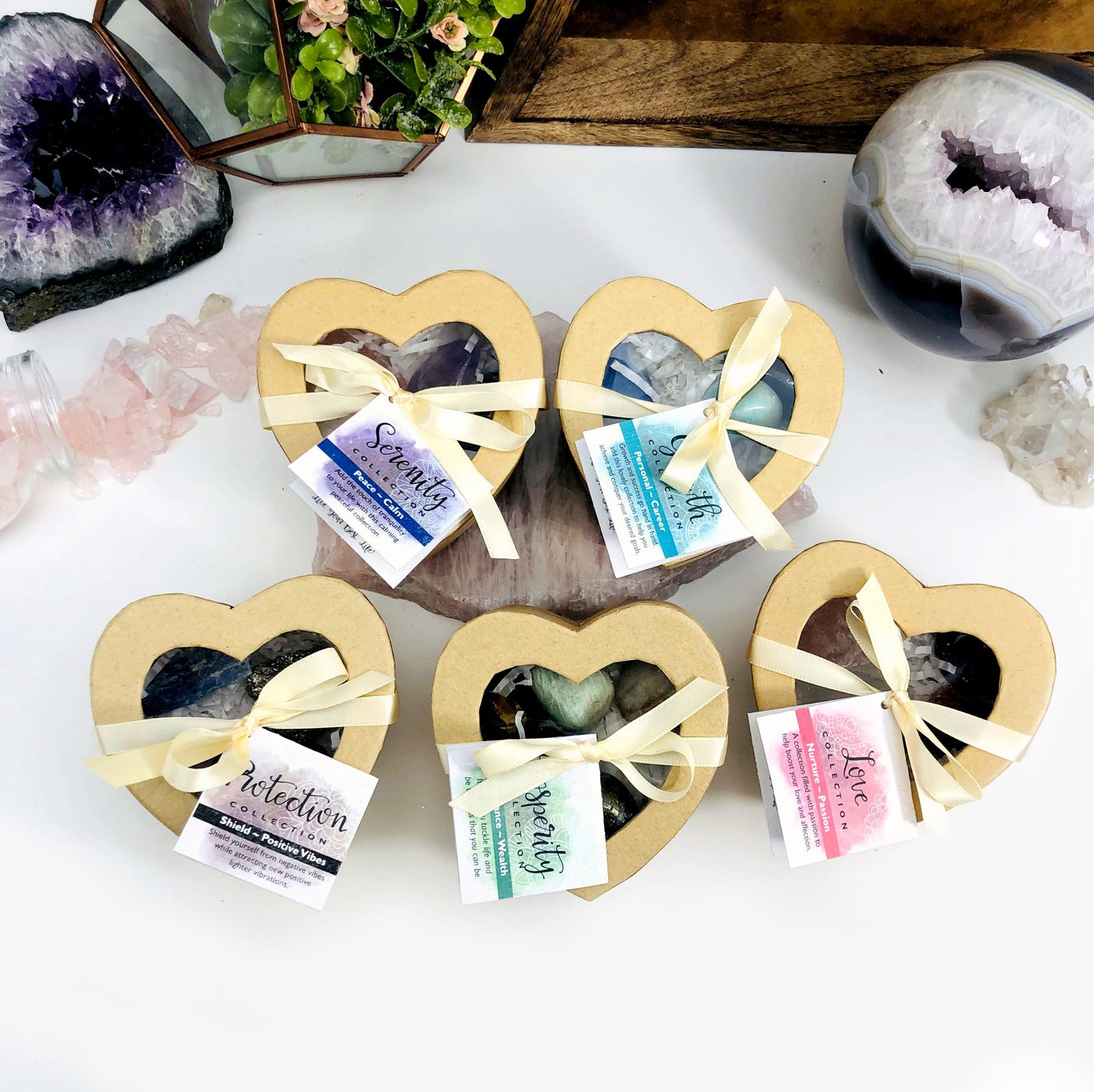 5 different crystal heart boxes with decorations in the background