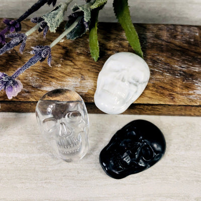 3 crystal skull cabochons on wooden plank with decorations