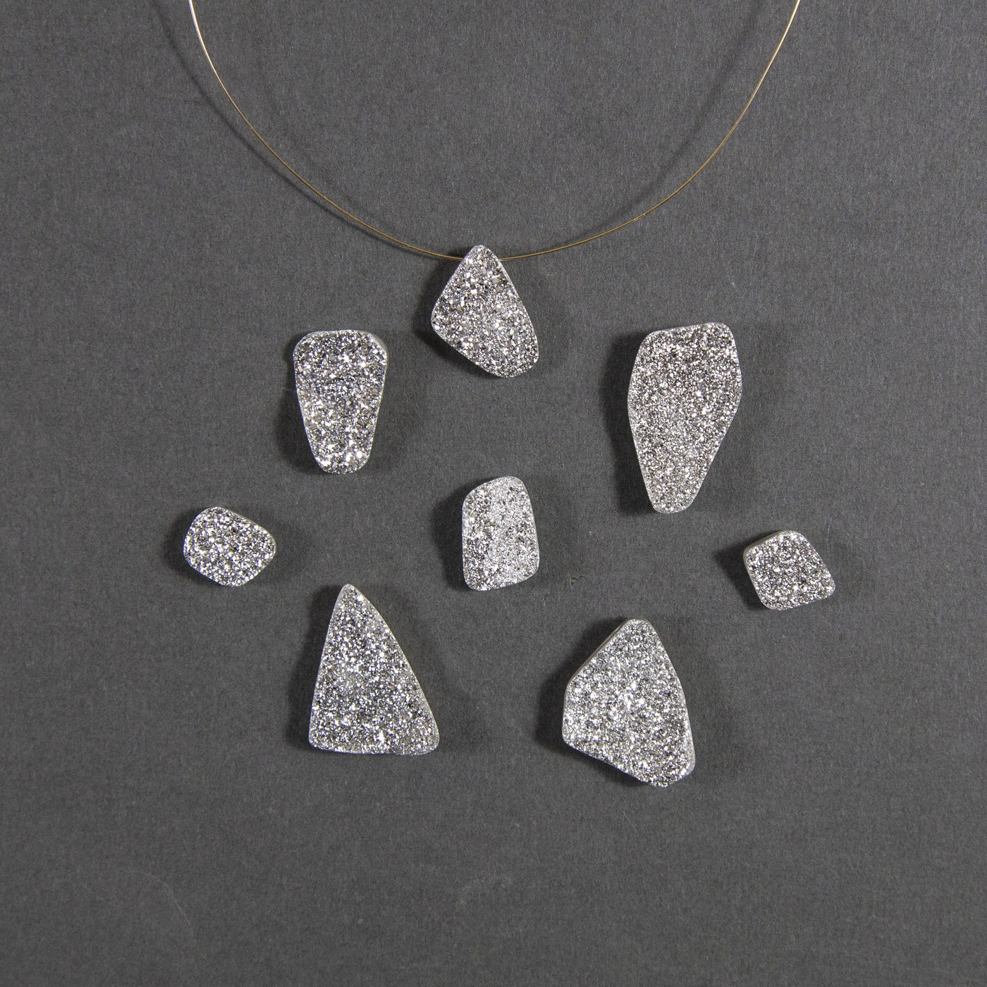 platinum druzy beads displayed with a wire through hole and up close to view various colors textures shapes sizes