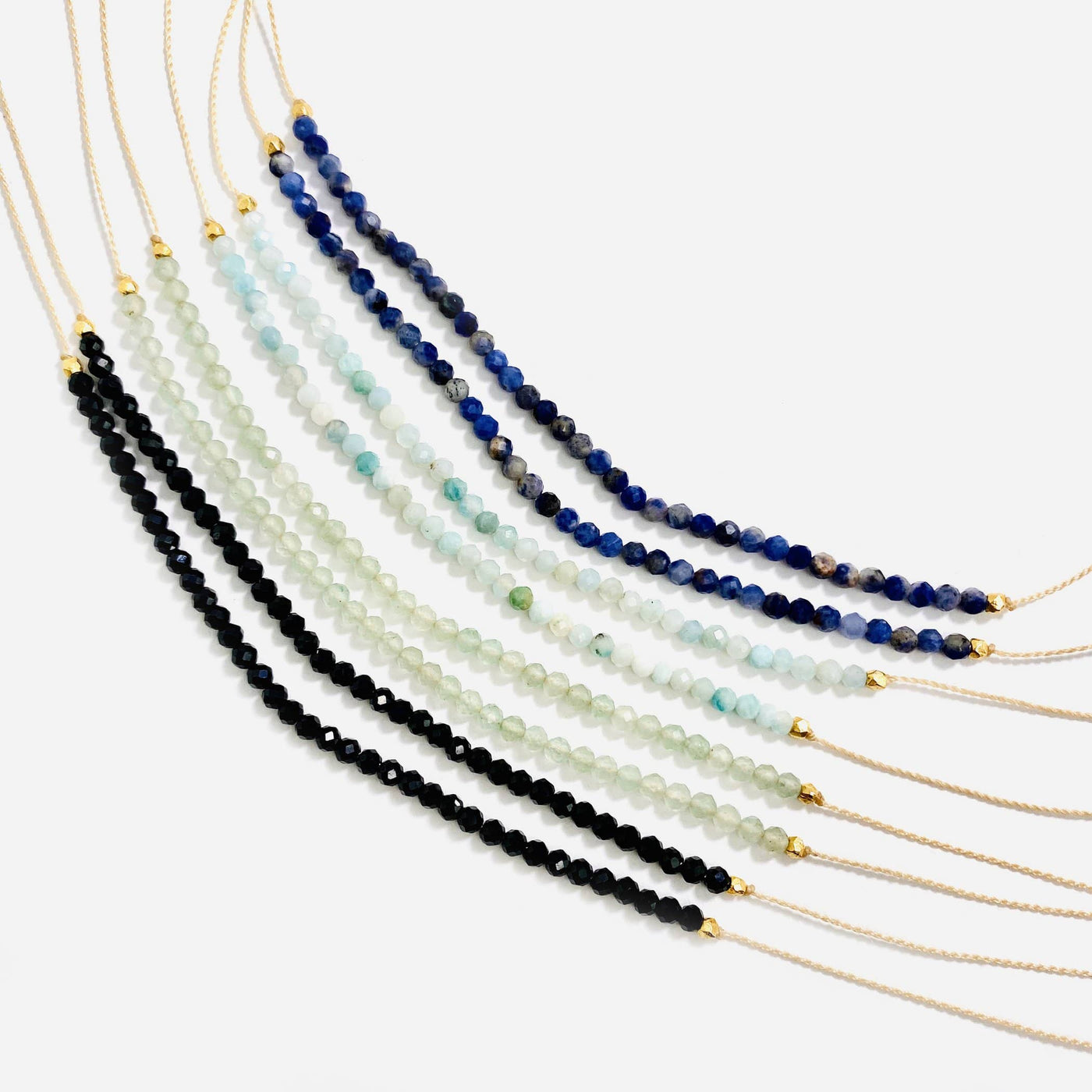 Gemstone Bead Finished Necklaces in different darker stones on a white background