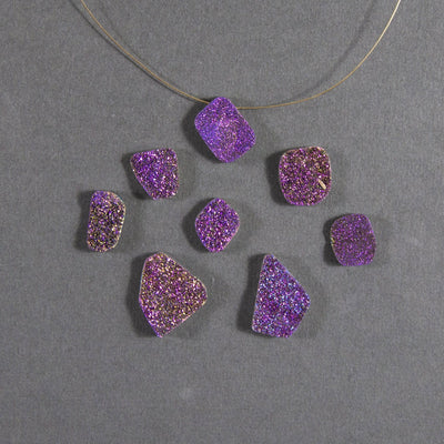 purple druzy beads displayed with a wire through hole and up close to view various colors textures shapes sizes