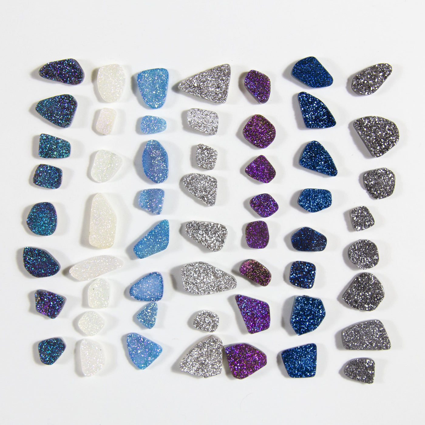multiple freeform Titanium Druzy Drilled Beads displayed on white background to show they come in rainbow white teal platinum purple mystic blue dark gray