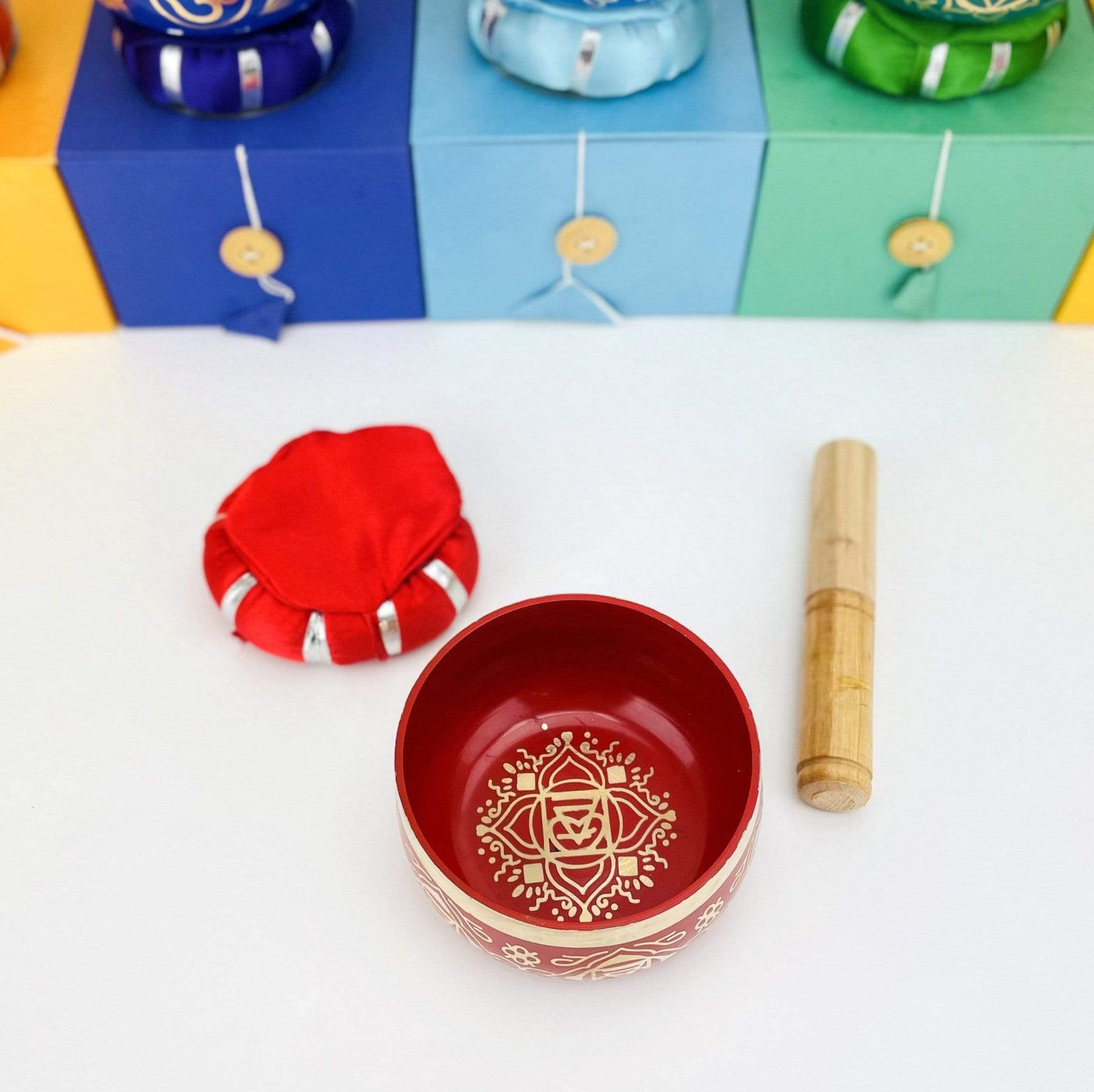 Red Brass Tibetan Chakra Singing Bowl shot from above, next to a pillow and a mallet