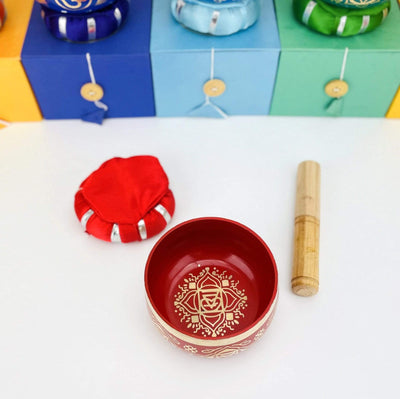 Red Brass Tibetan Chakra Singing Bowl shot from above, next to a pillow and a mallet