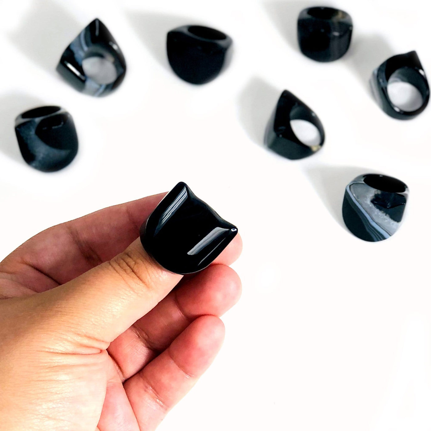 Hand holding up close one of the Black Agate Polished Rings