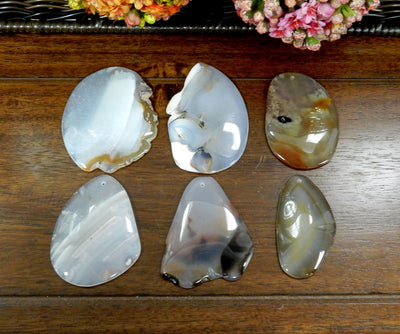 6 Natural FreeForm Agate Slices with Polished Edge on Wooden Background.