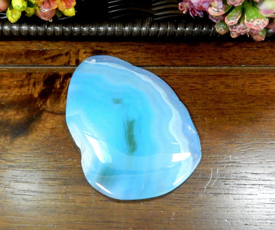 Light Blue Drilled Freeform Agate Slices With Polished Edge on Wooden Background.