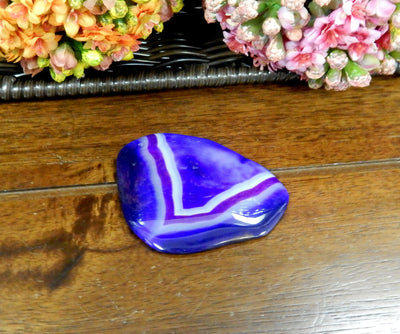 Purple Drilled Freeform Agate Slices With Polished Edge on Wooden Background.