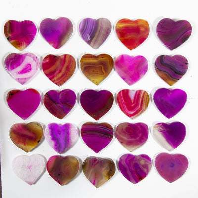 Multiple pink Agate Heart Shaped Cabochons displayed on a white background to display color and pattern variation.