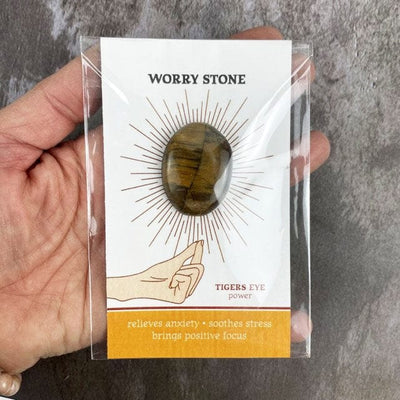 Tigers eye worrystone on a card up close in a hand