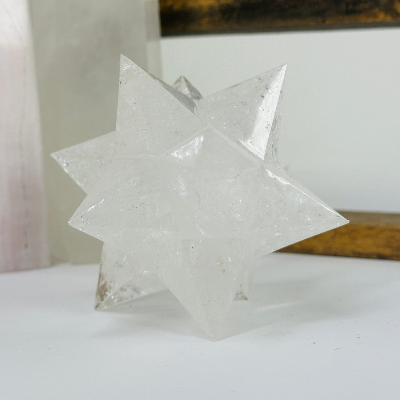 crystal quartz merkaba with decorations in the background