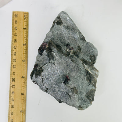 garnet on hematite matrix next to a ruler for size reference