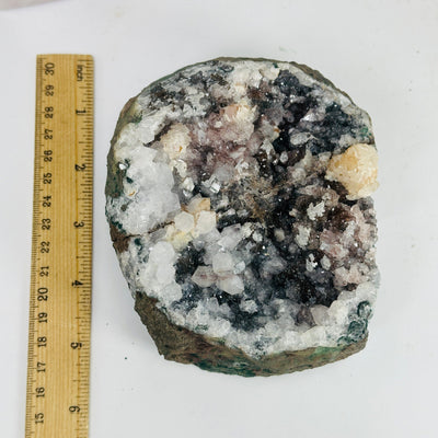 amethyst cluster next to a ruler for size reference