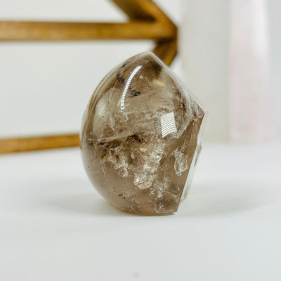 polished smokey quartz with decorations in the background