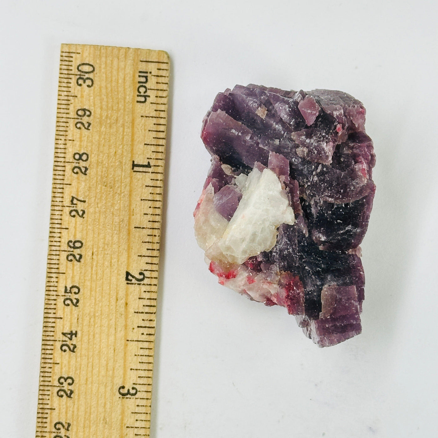 lepidolite cluster with decorations in the background