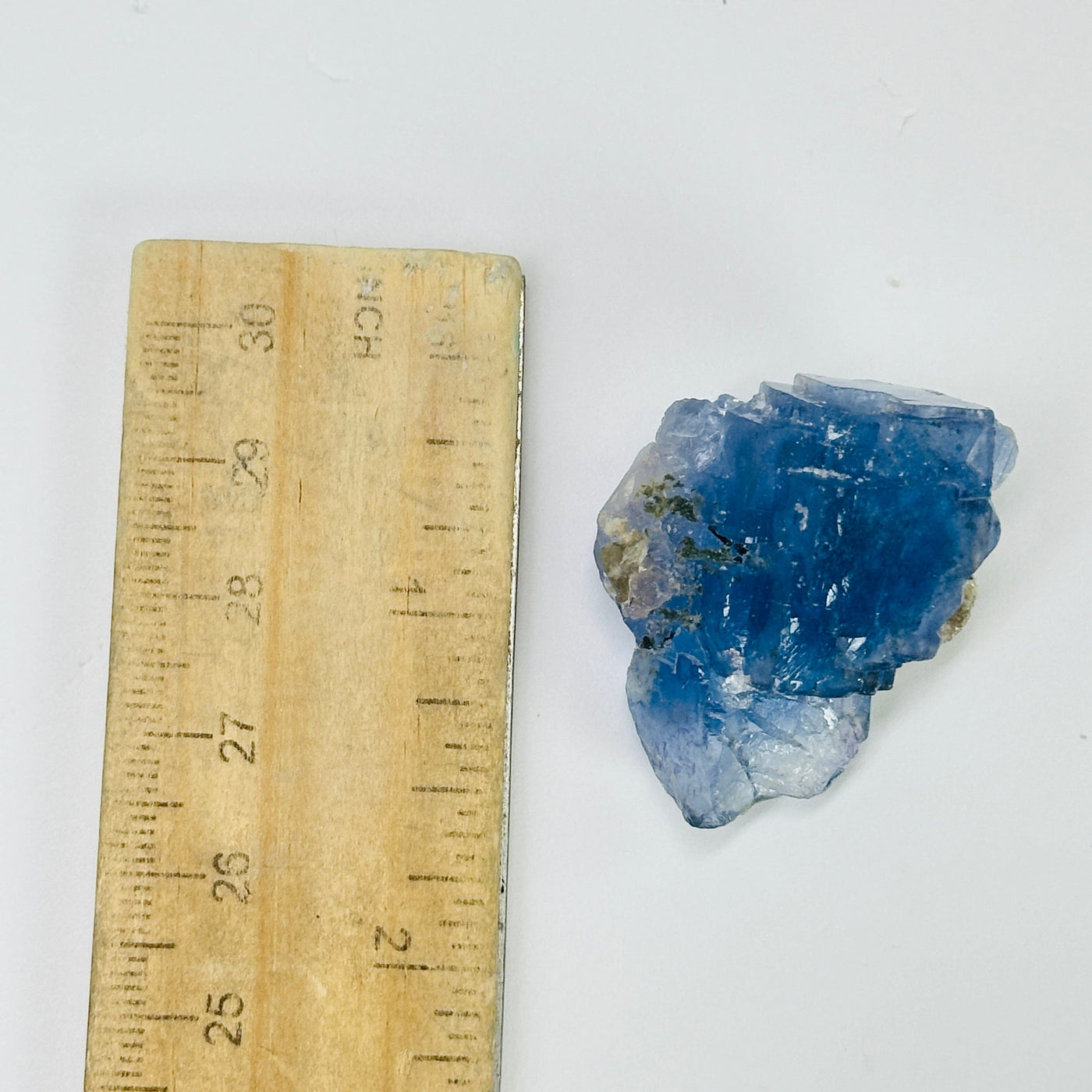 blue fluorite next to a ruler for size reference