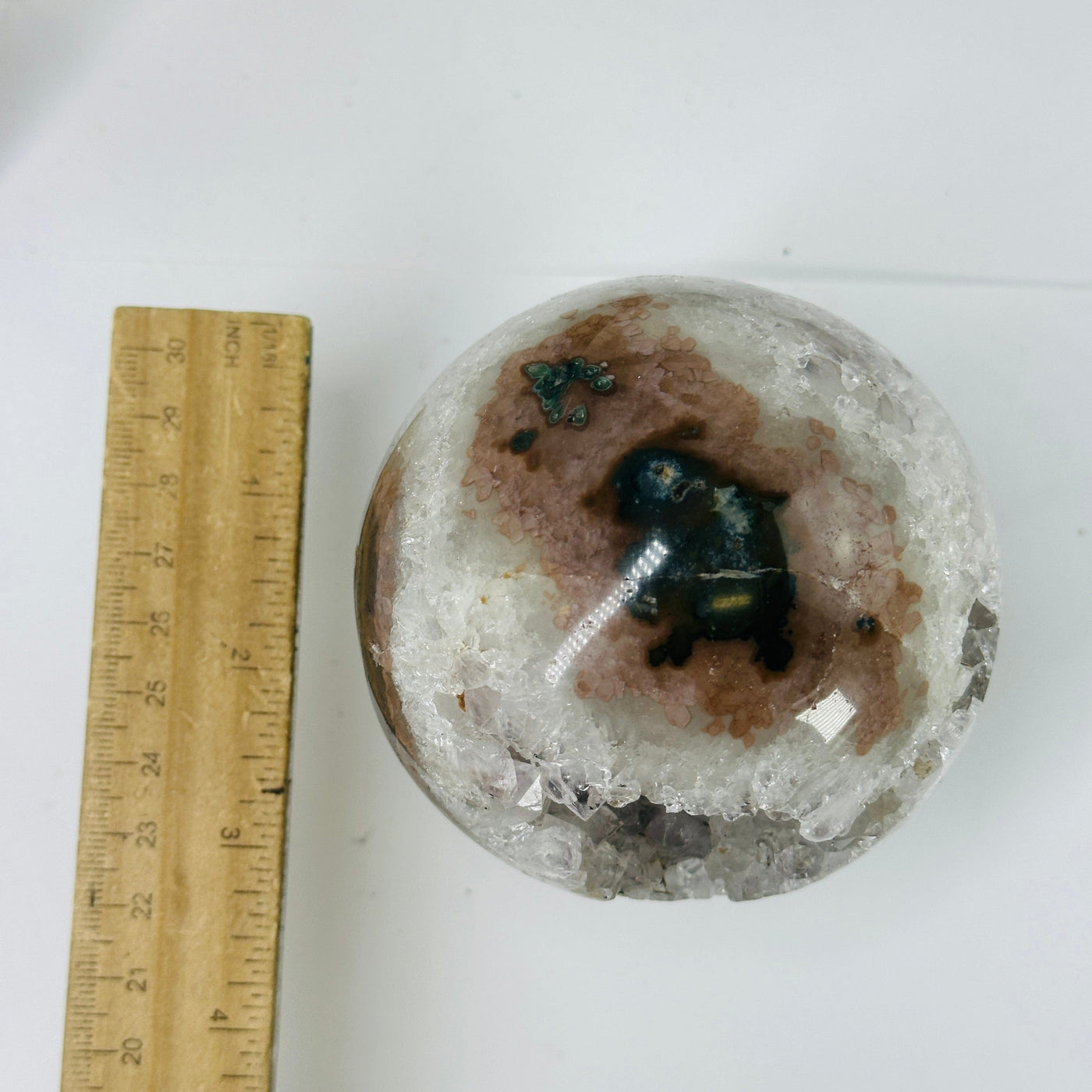 amethyst sphere next to a ruler for size reference