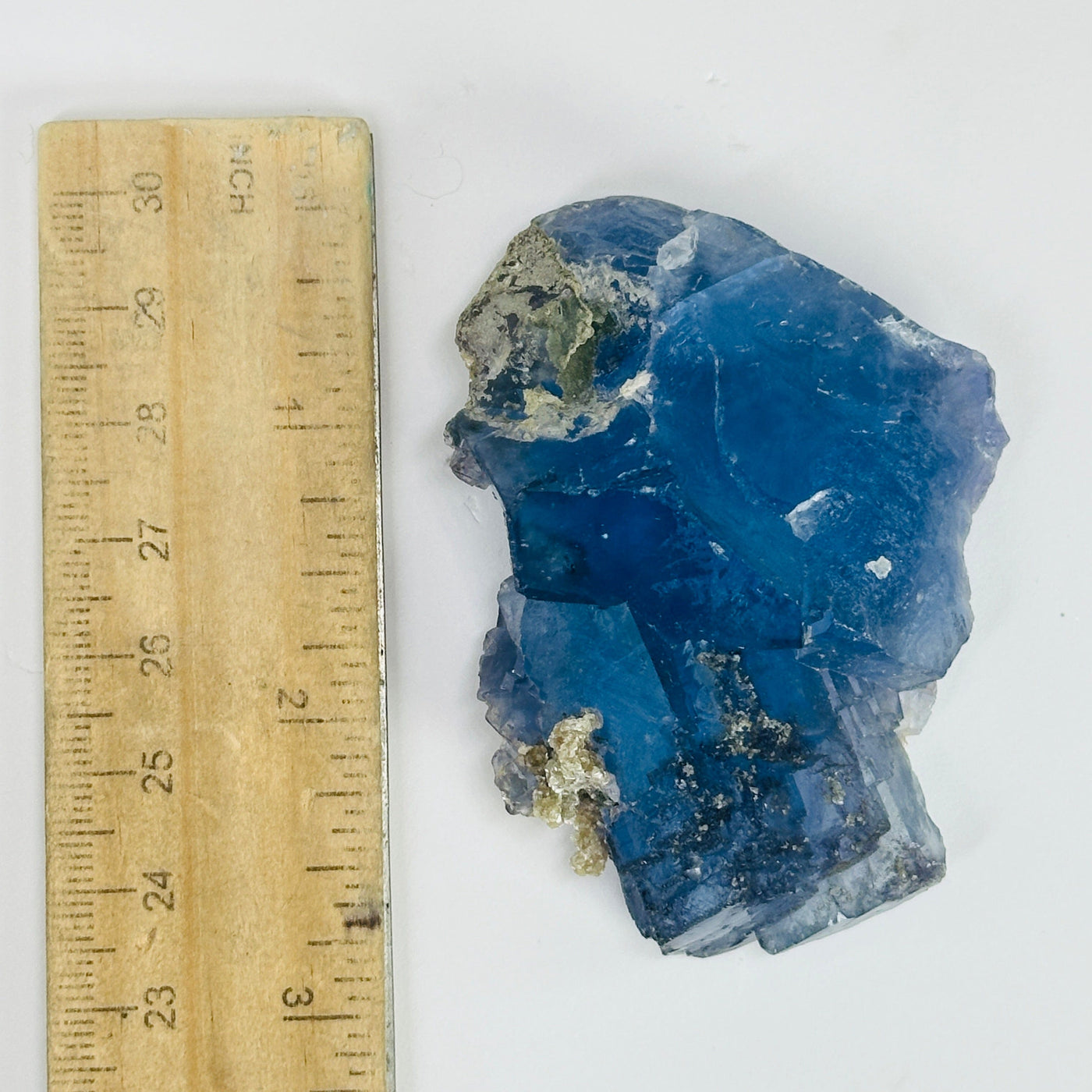 blue fluorite next to a ruler for size reference