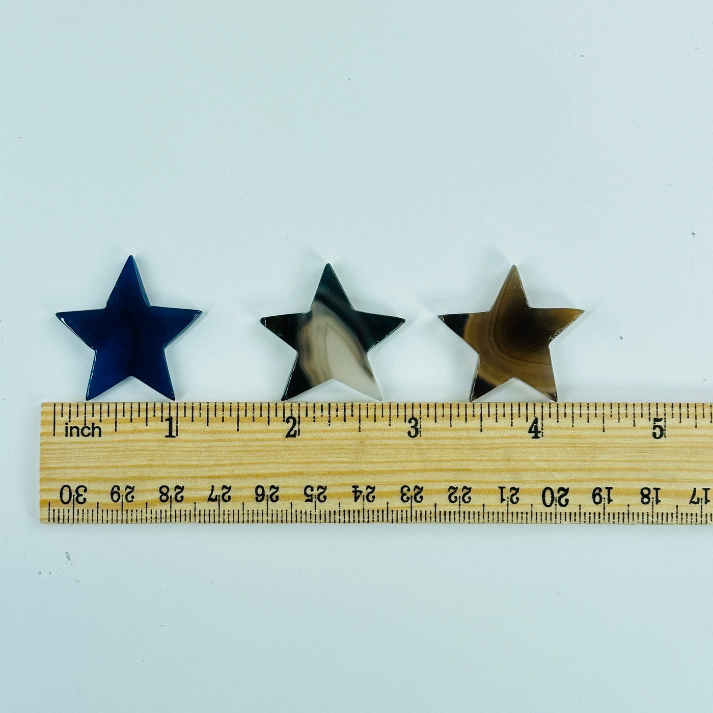 dyed agate stars next to a ruler for size reference