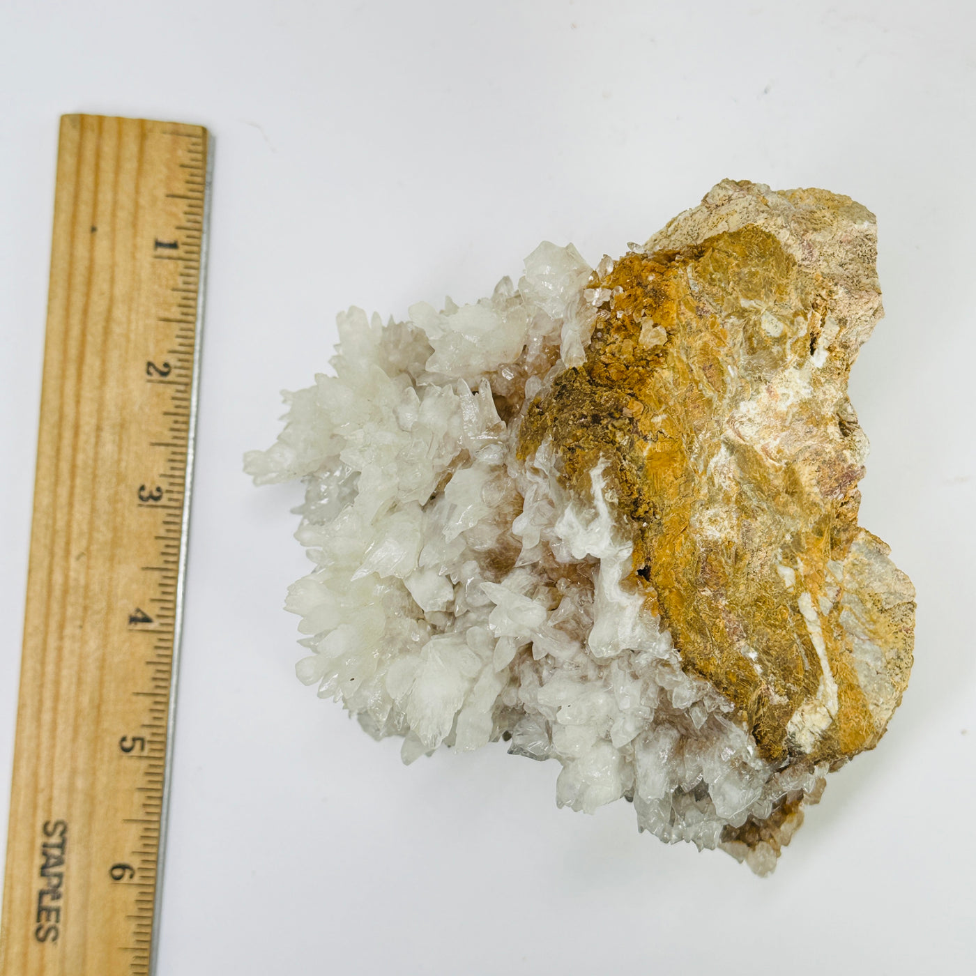 calcite on matrix next to a ruler for size reference