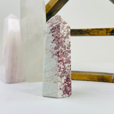 pink tourmaline point with decorations in the background