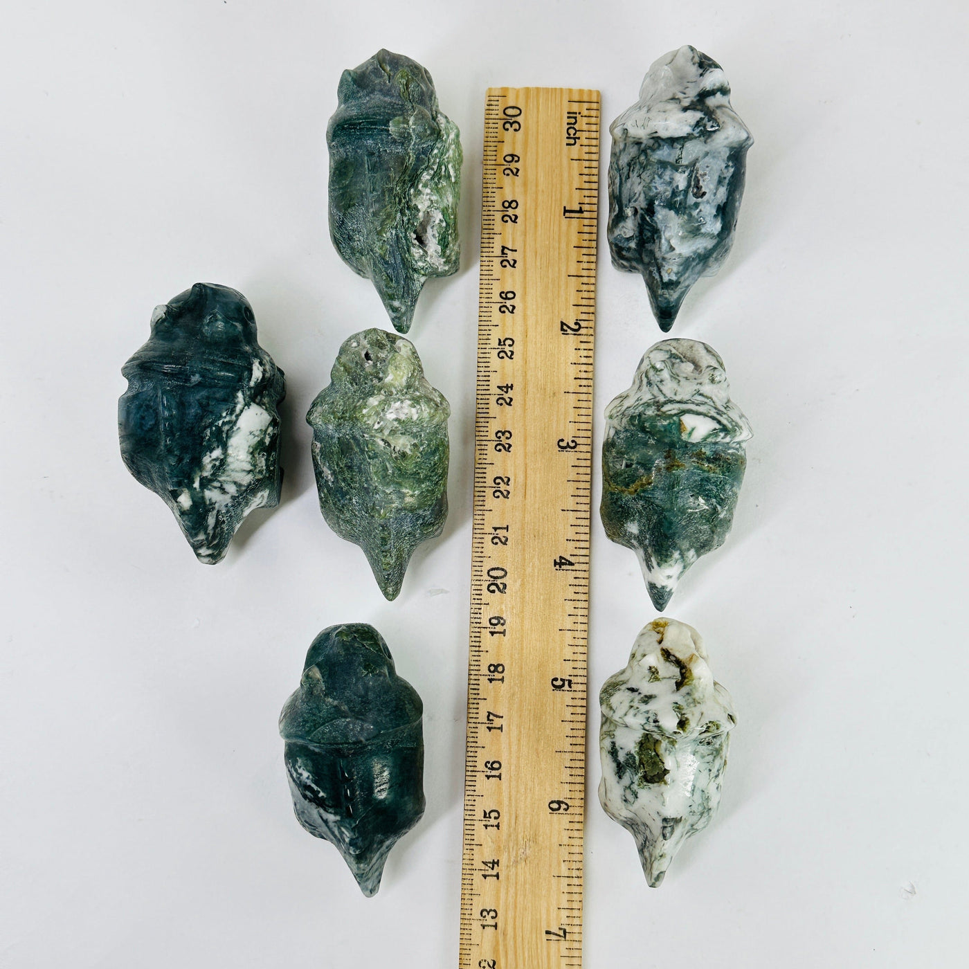 moss agate triceratops next to a ruler for size reference