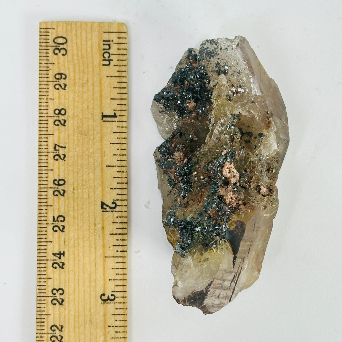 rutilated quartz next to a ruler for size reference