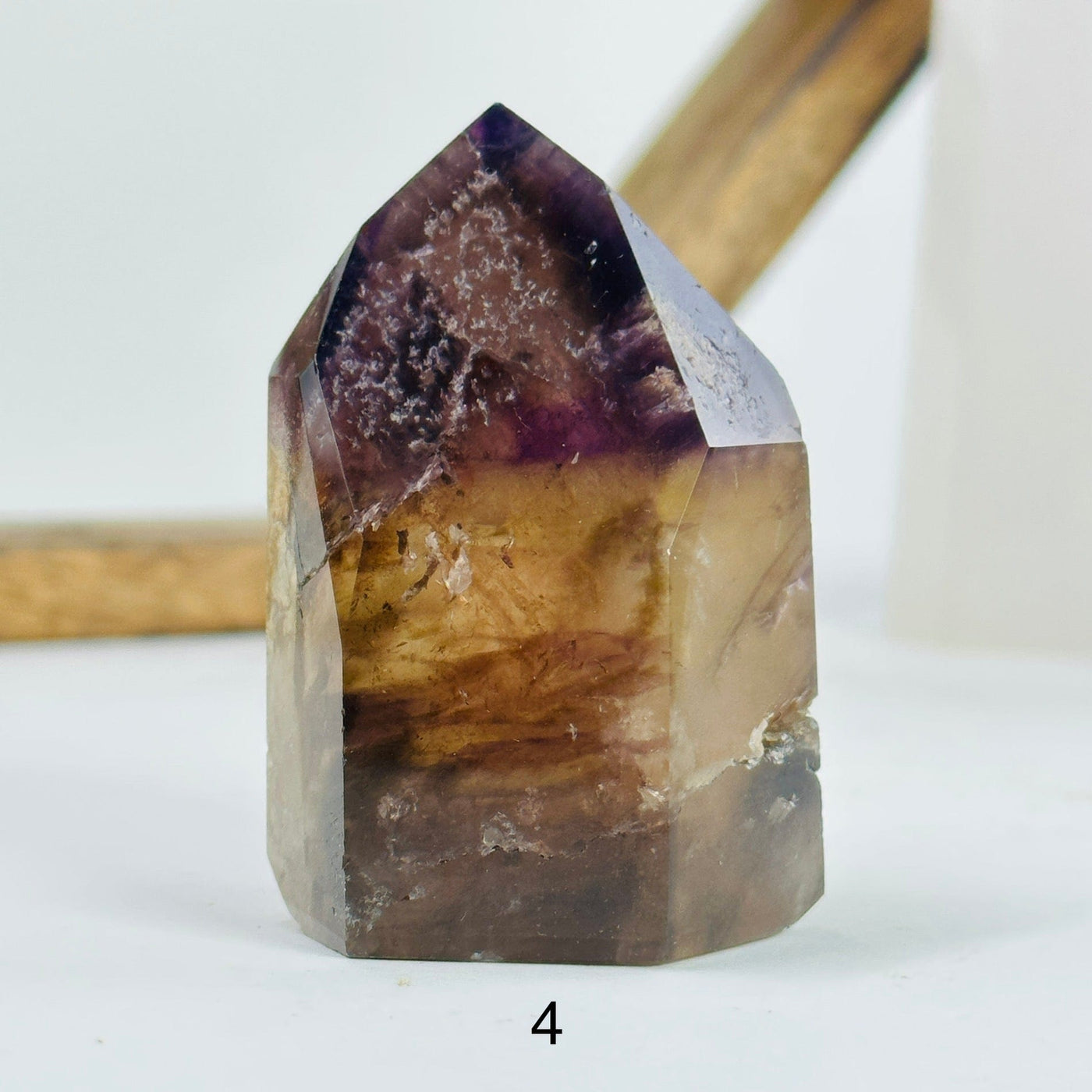 ametrine polished point with decorations in the background