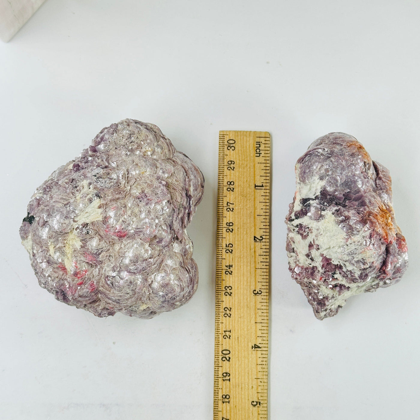 lepidolite cluster next to a ruler for size reference