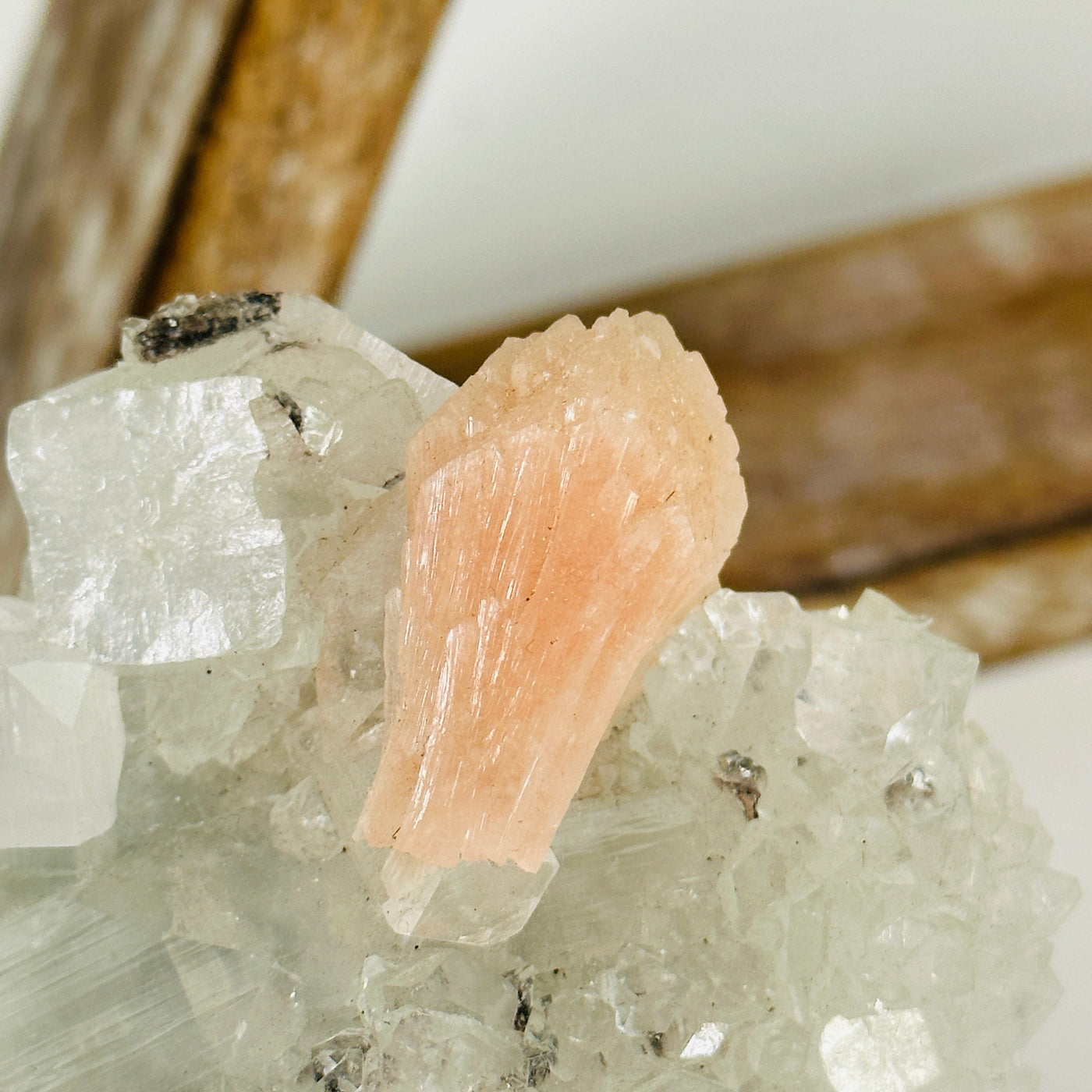 up close shot of peach apophyllite with Stilbite with decorations in the background