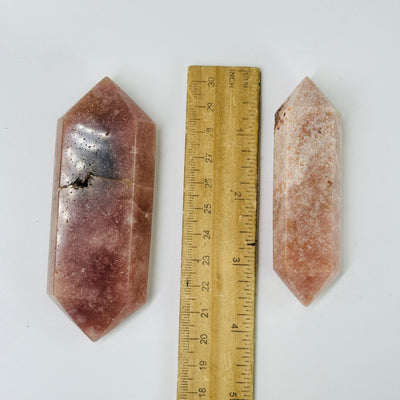 pink amethyst points next to a ruler for size reference