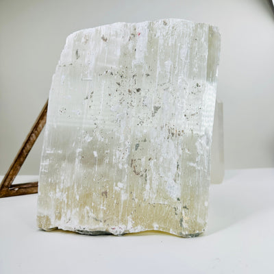 selenite cluster with decorations in the background