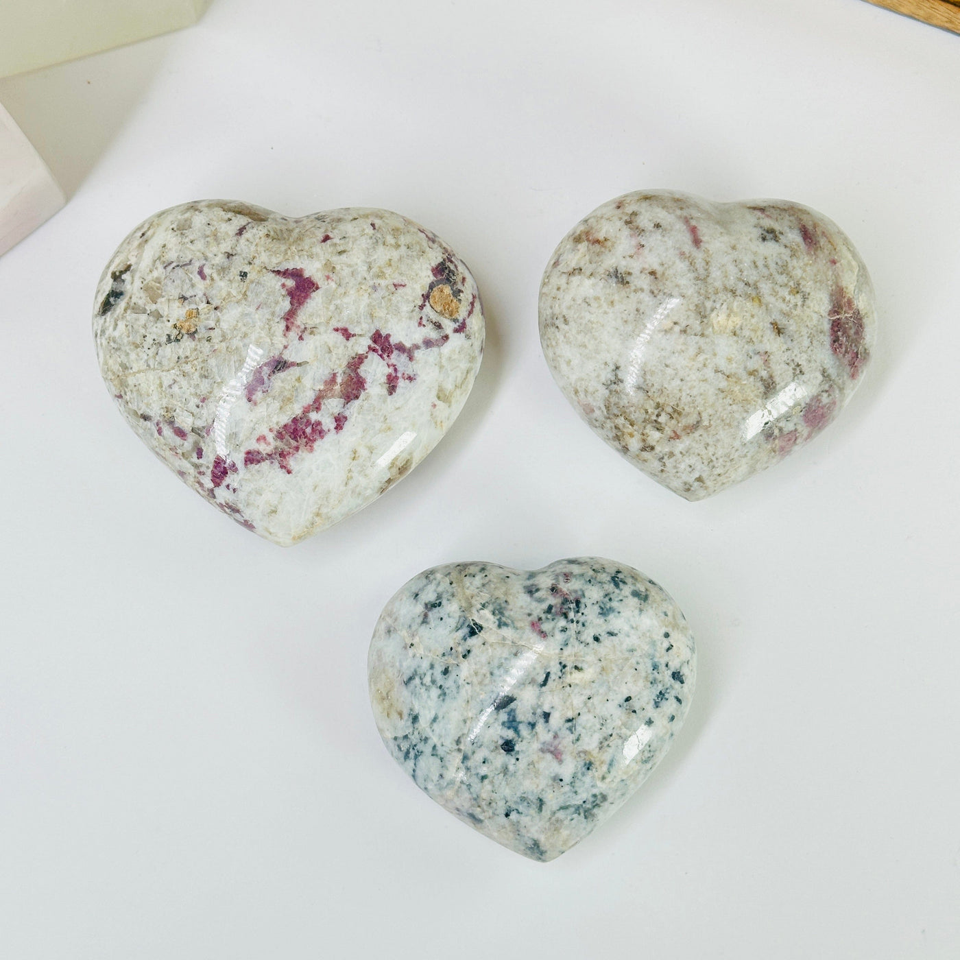 pink tourmaline heart with decorations in the background