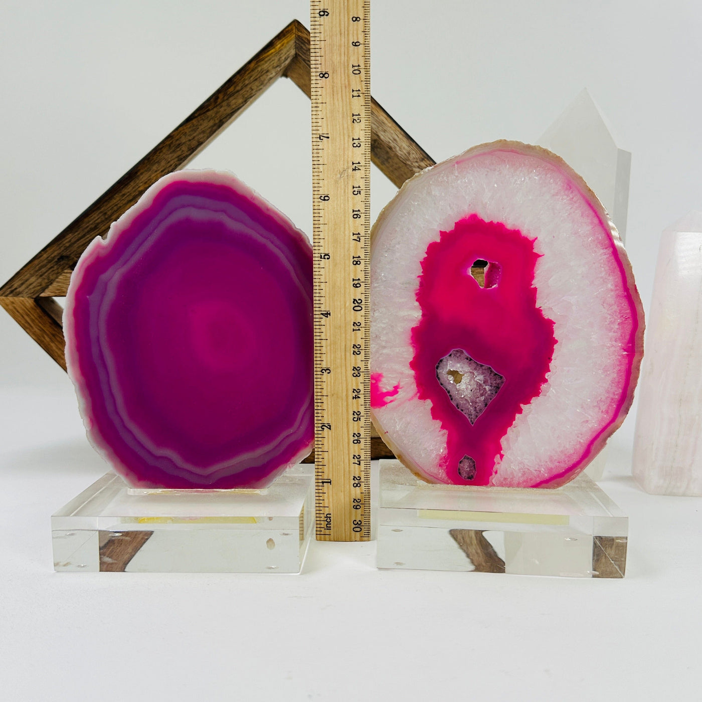 pink agate slice on acrylic stand next to a ruler for size reference