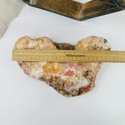 pink amethyst next to a ruler for size reference