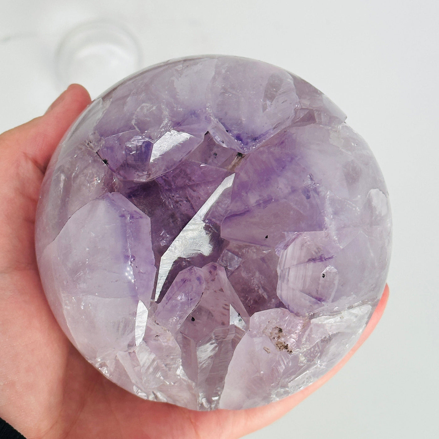 hand holding up amethyst sphere