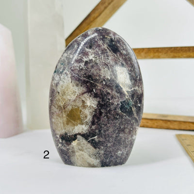 lepidolite cut base with decorations in the background