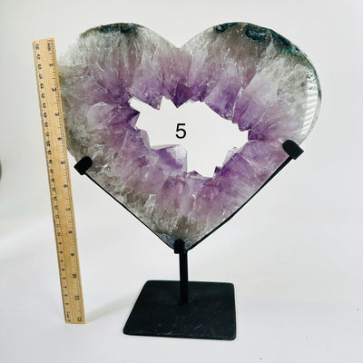 amethyst heart on stand next to a ruler for size reference