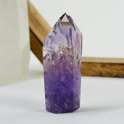amethyst polished point with decorations in the background
