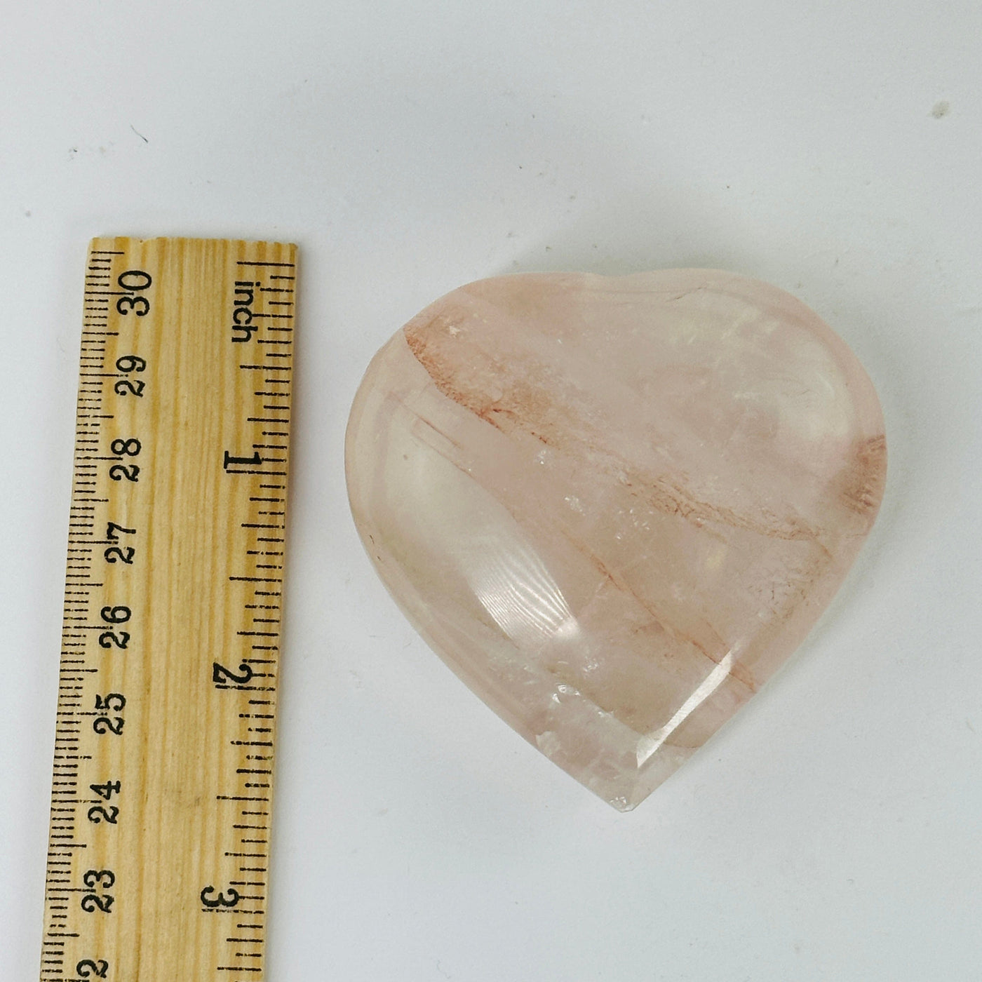 ROSE QUARTZ HEART next to a ruler for size reference