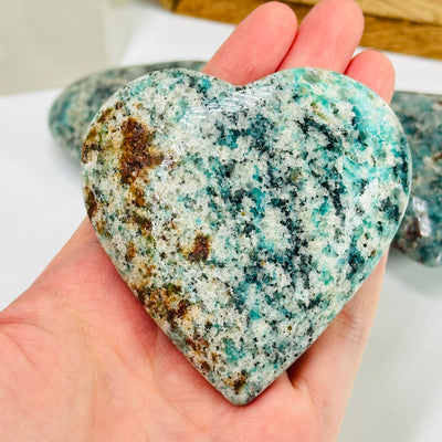 amazonite heart with decorations in the background