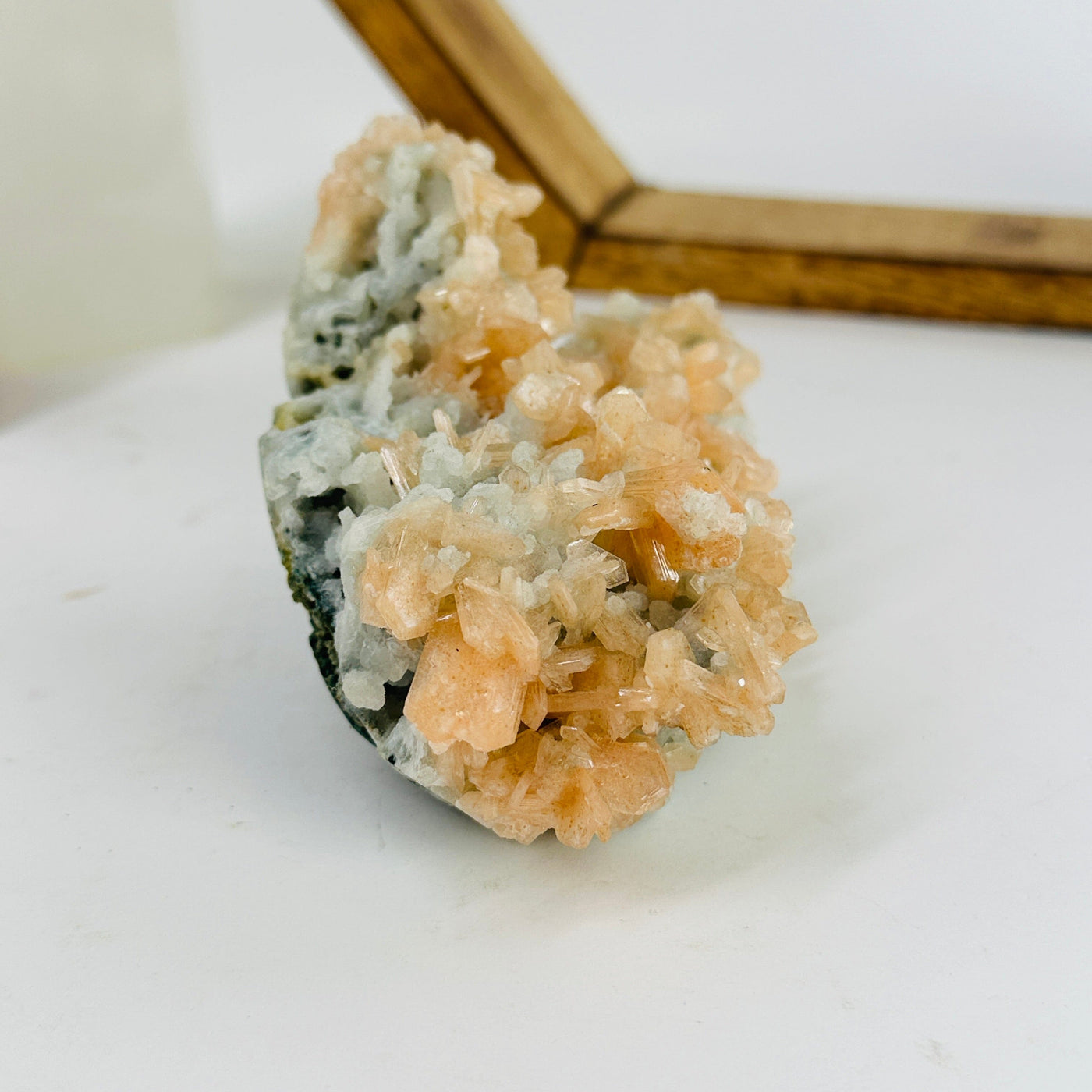 apophyllite with peach stilbite with decorations in the background