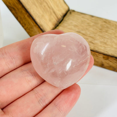 rose quartz heart with decorations in the background
