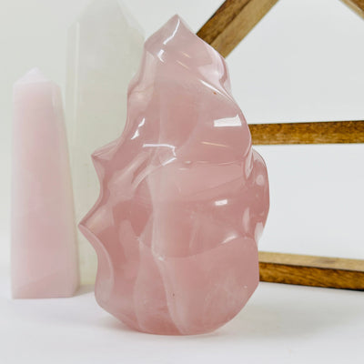 rose quartz flame point with decorations in the background