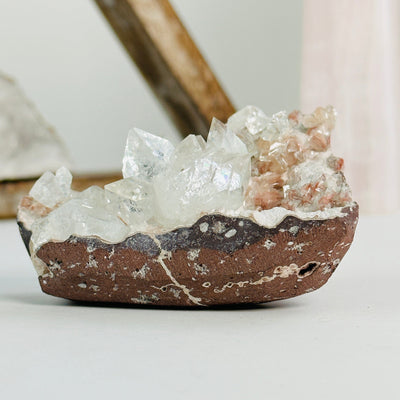 apophyllite on matrix with decorations in the background