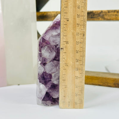 amethyst point next to a ruler for size reference