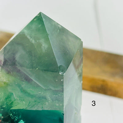 fluorite point with decorations in the background